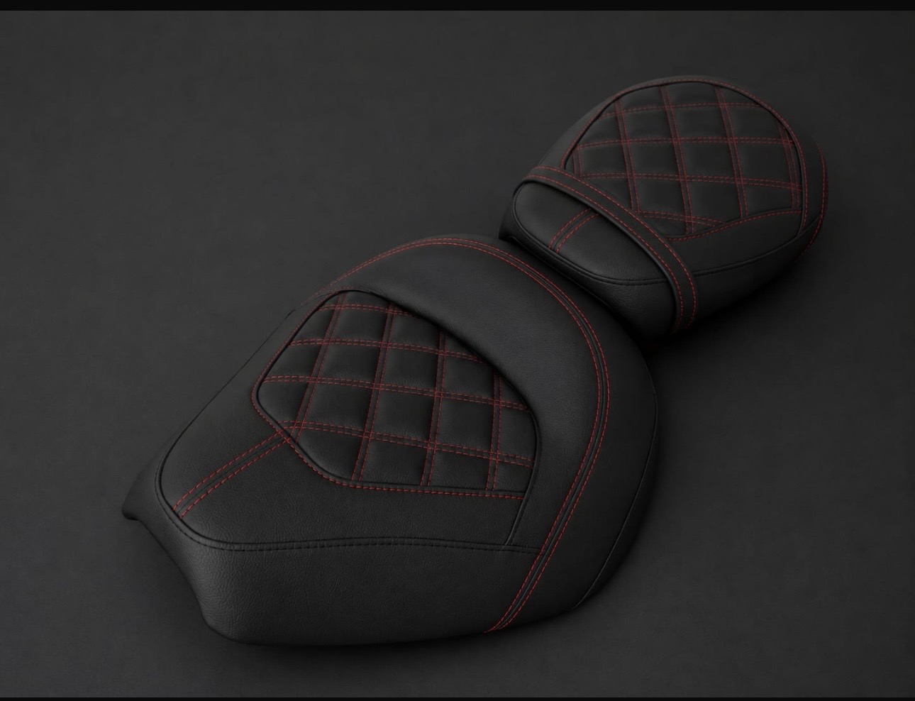 Asiento de moto custom tapizado en piel negra con capitoné de rombos y costura roja